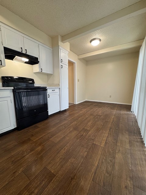 A kitchen with white cabinets and a black stove top oven.