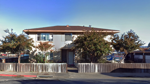 A house with a brown roof and a white fence.