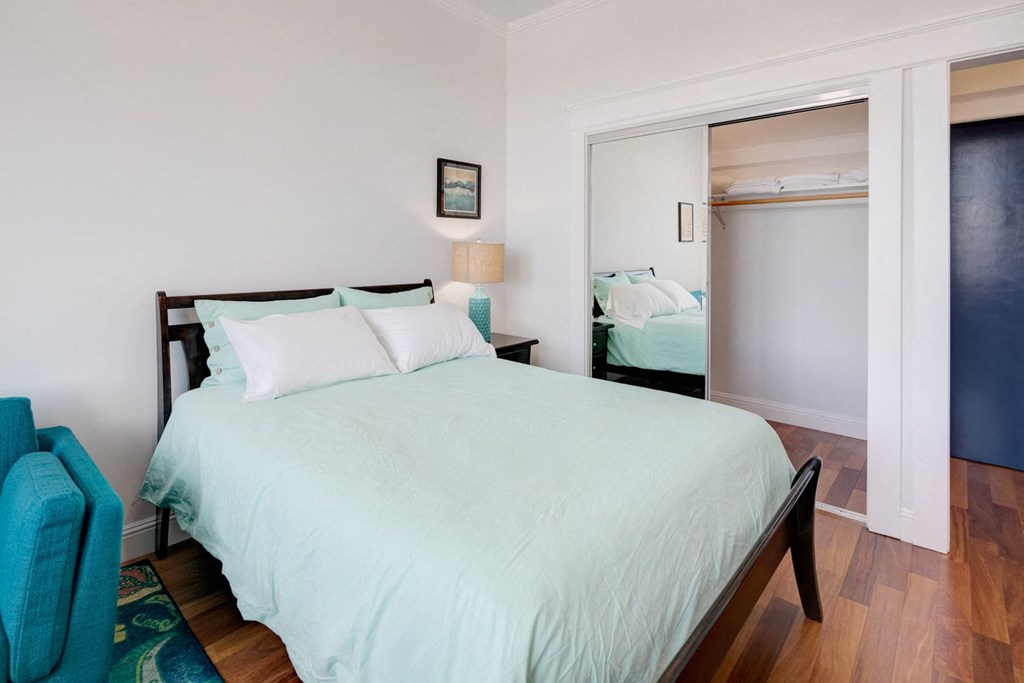 a bedroom with a large bed and a door to a closet