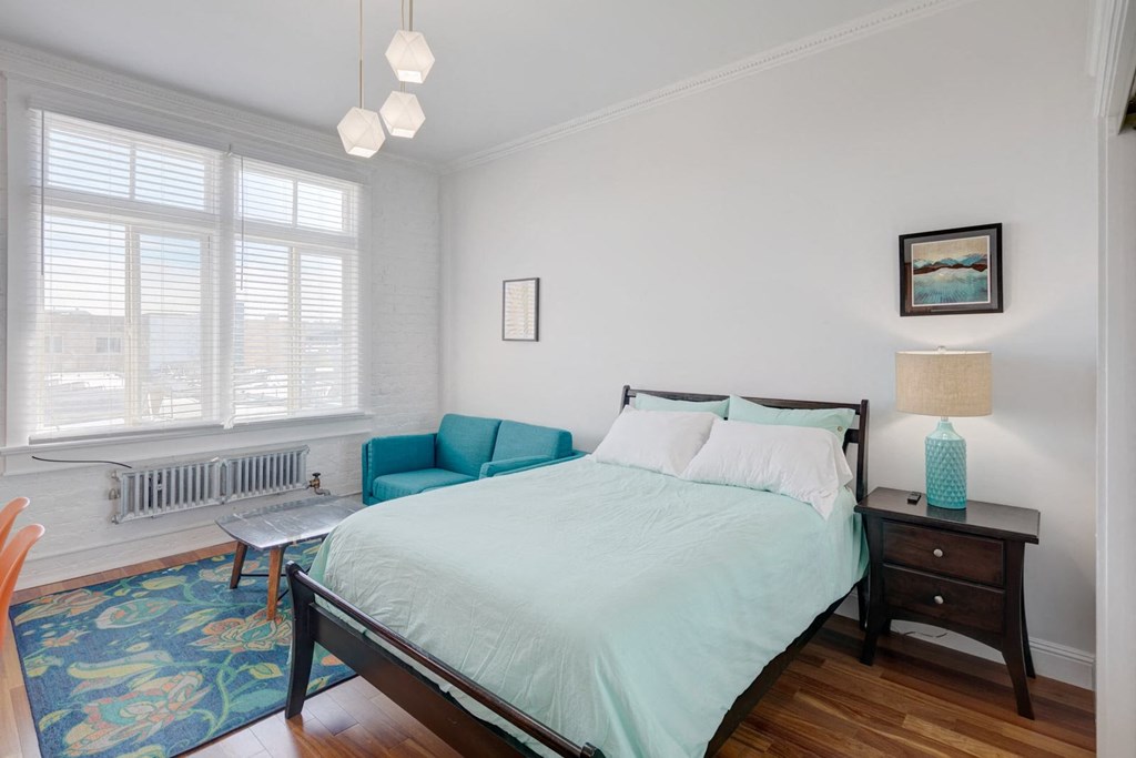 a bedroom with a bed and a blue couch