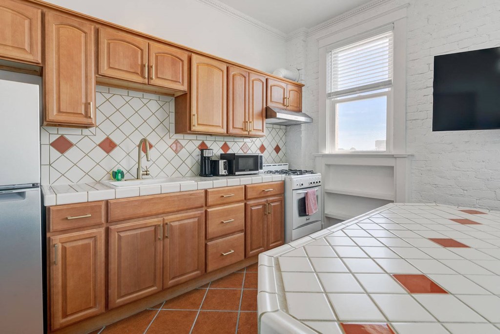 a kitchen with wooden cabinets and a white counter top