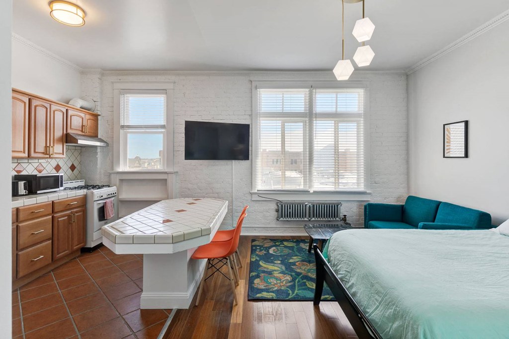 a bedroom with a bed and a kitchen