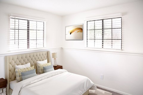 A bedroom with a large bed and a painting on the wall.