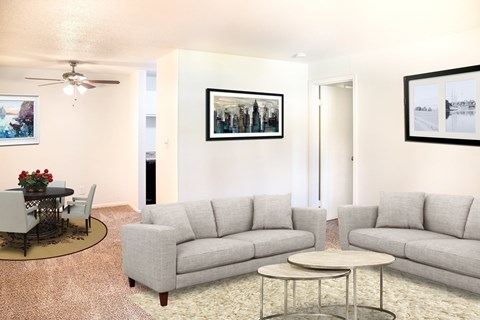 A living room with a grey couch, a coffee table, and a painting on the wall.