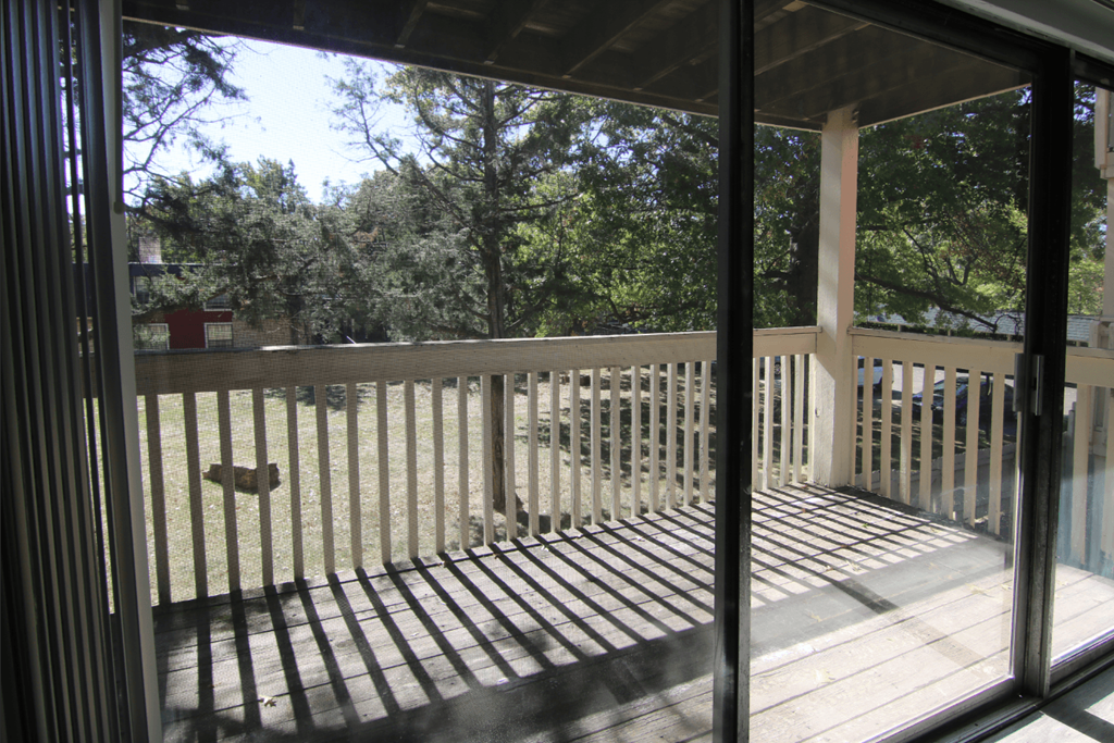 A balcony with a railing and a view of trees.