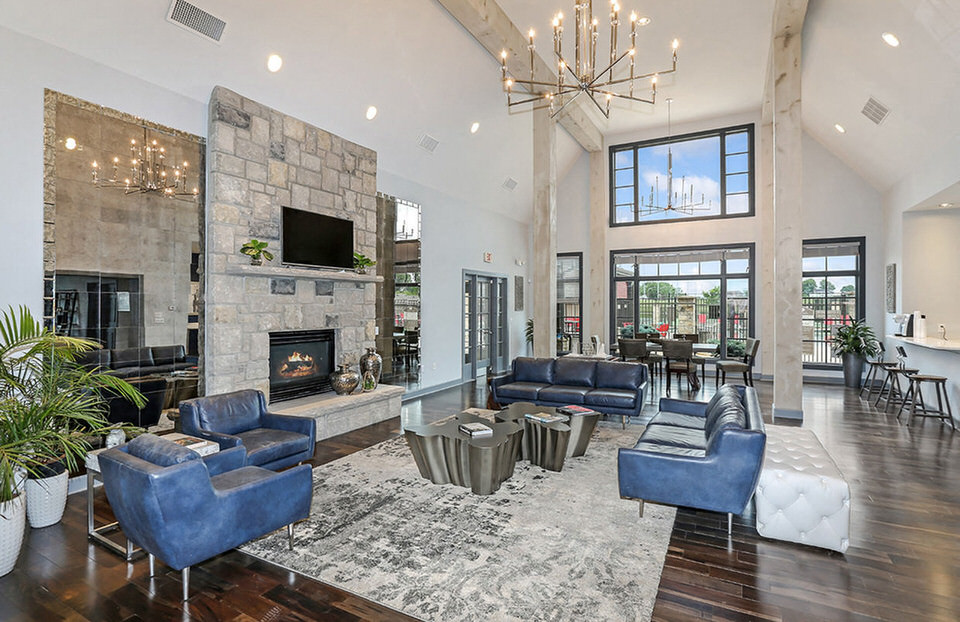 a large living room with blue furniture and a fireplace
