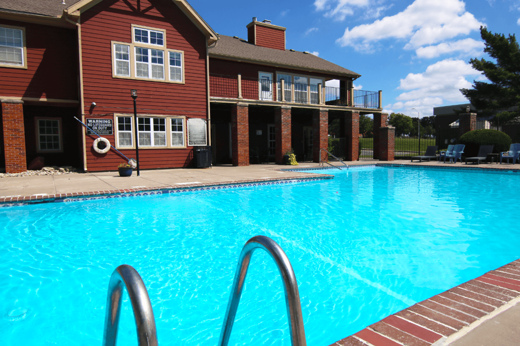 A swimming pool in front of a red brick building.