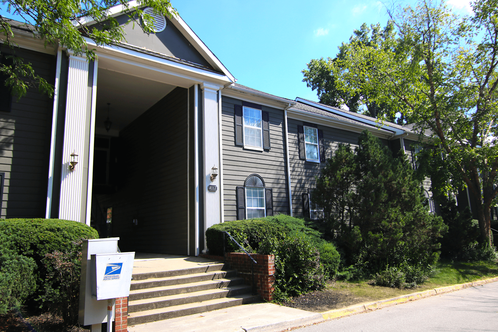 A grey house with a mailbox in front.
