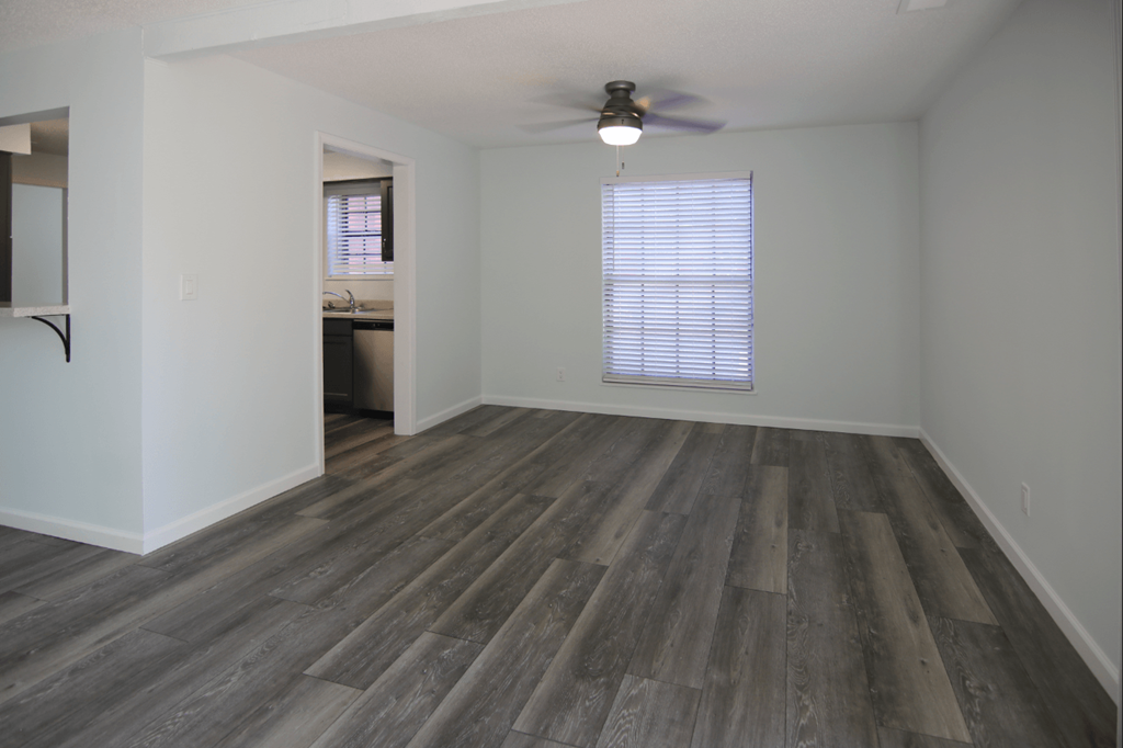 A room with wooden flooring and a ceiling fan.