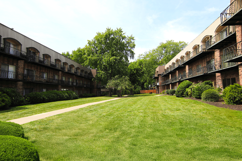 A grassy area in front of apartment buildings.