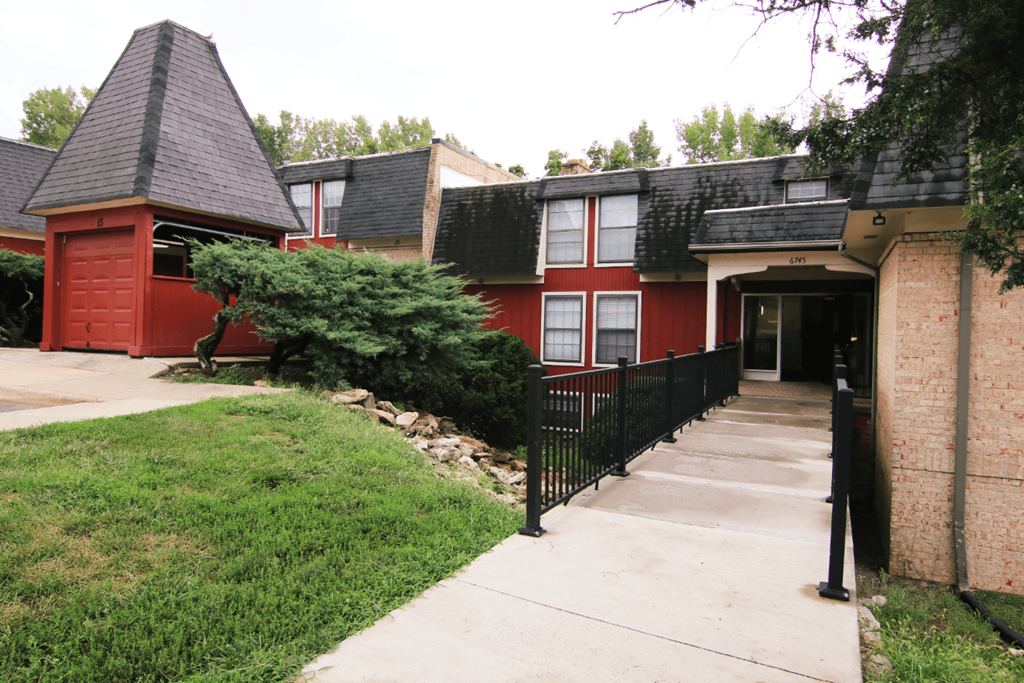 A red house with a black fence in front.