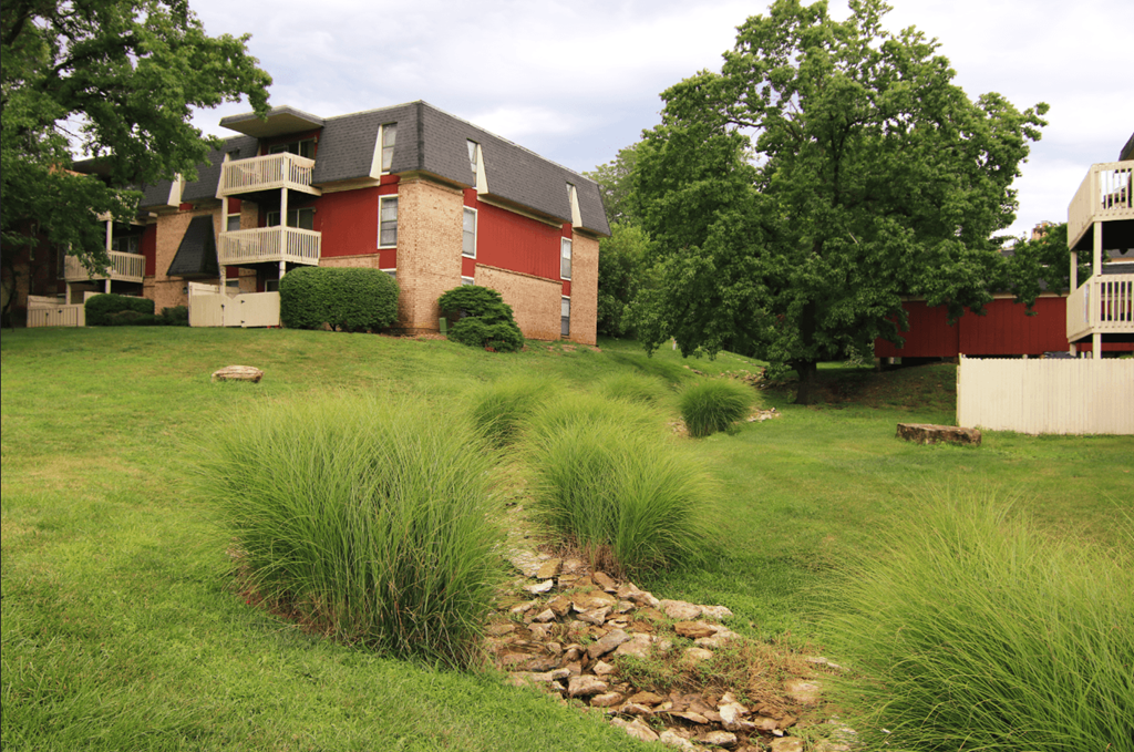 A grassy area in front of a red building.