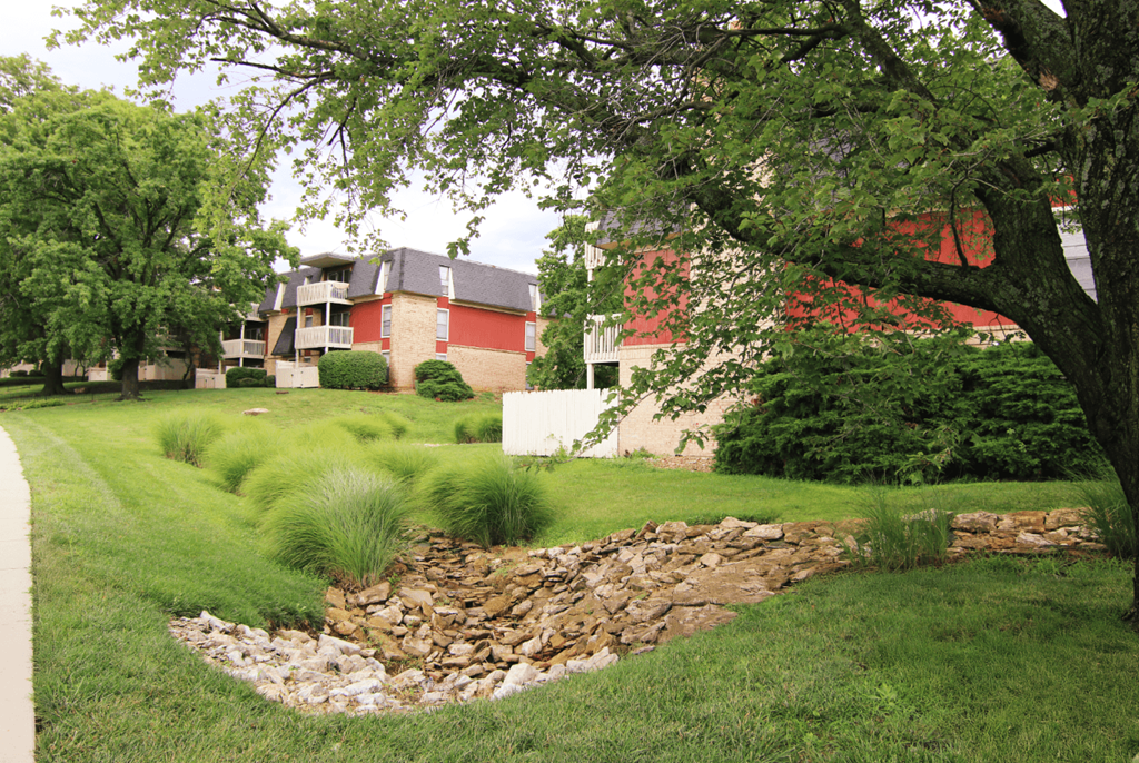 A red building with a stone wall in front of it.