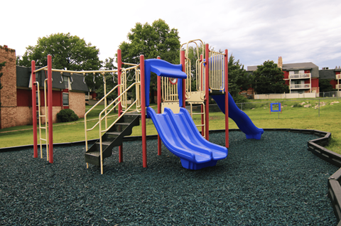 A playground with a blue slide and a yellow and red structure.