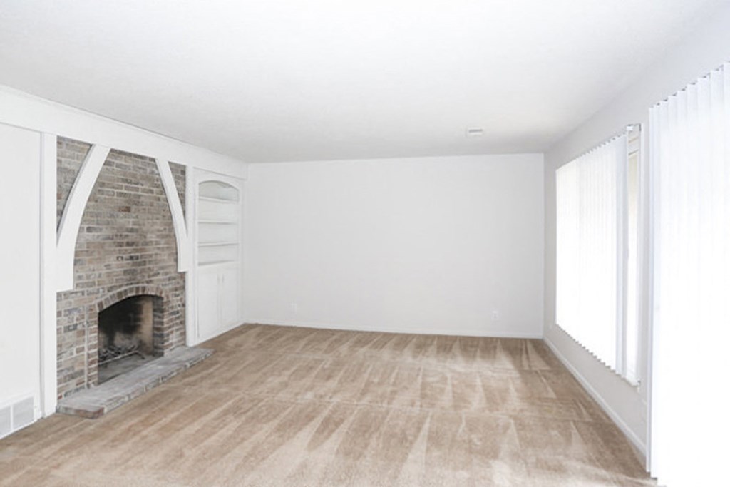 Living Room with fireplace and built-in shelves at Canyon Creek Apartments, Missouri