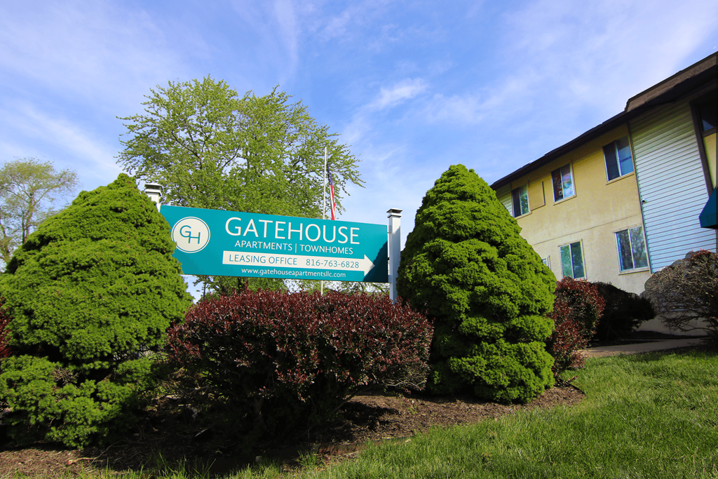 a building with a gatehouse sign in front of bushes and trees at Gatehouse Apartments, Kansas City, MO, Missouri
