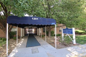 a blue awning over a sidewalk in front of a brick building
