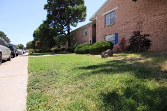 a grassy area in front of a brick building