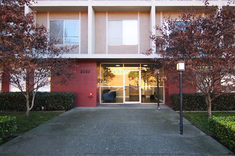 A building with a red wall and a glass door.