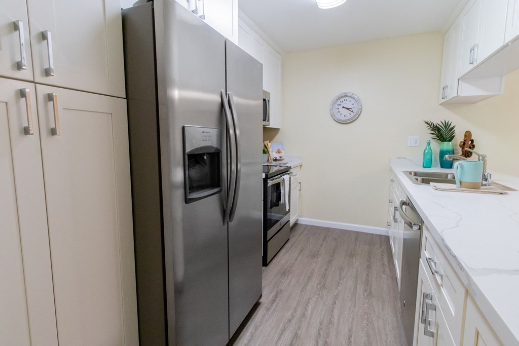 a kitchen with stainless steel appliances and white cabinets