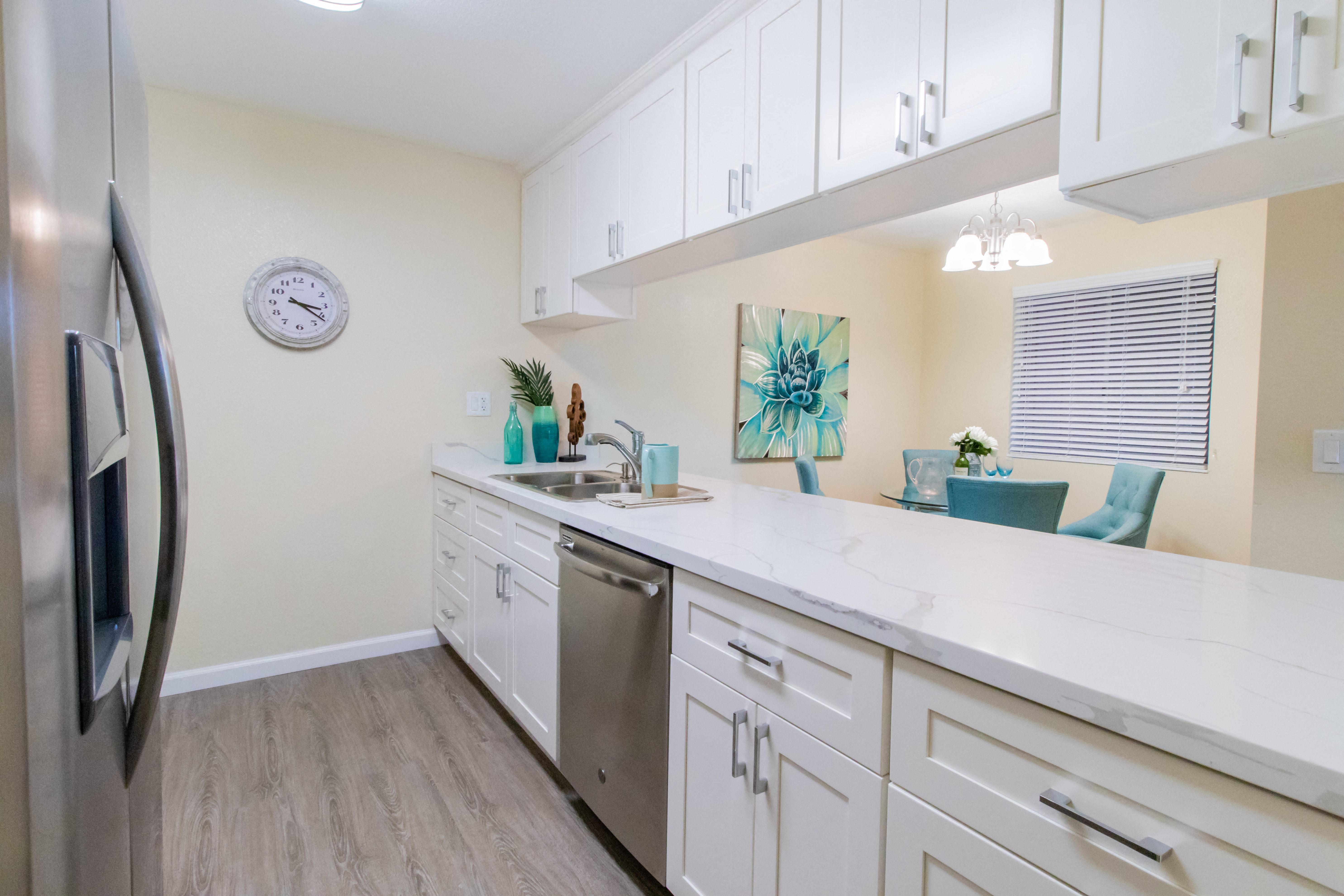 a kitchen with white cabinets and a stainless steel refrigerator