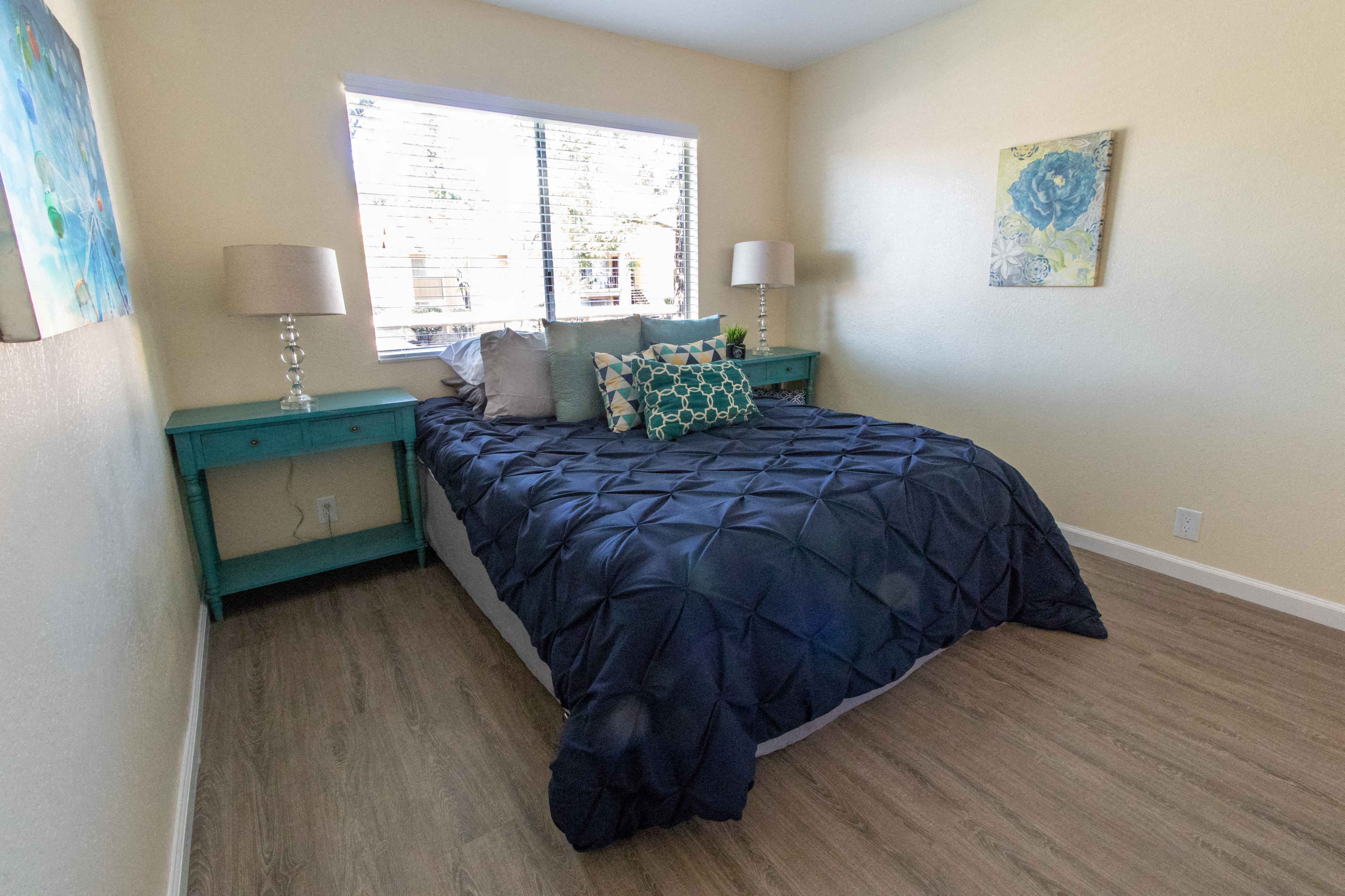 a bedroom with a bed and two night stands and a window