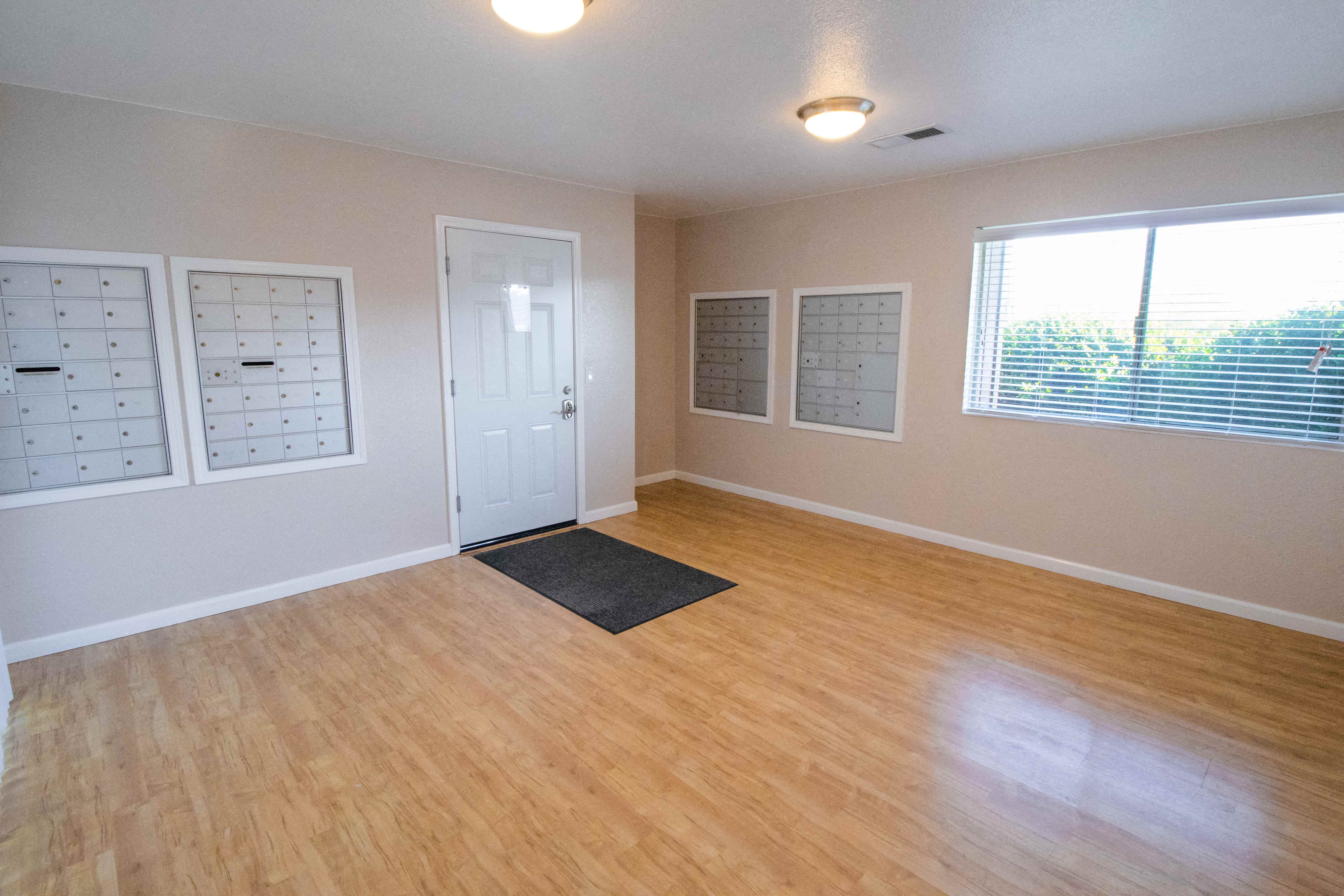 an empty living room with a hard wood floor and a window