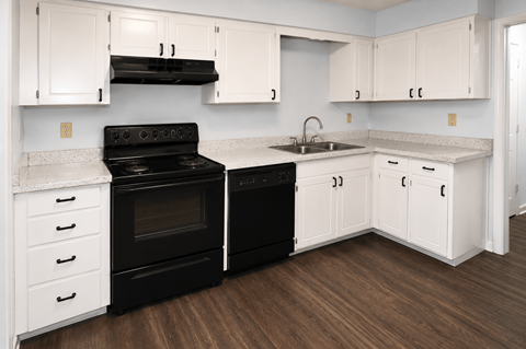 A kitchen with black appliances and white cabinets.