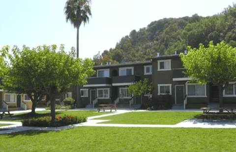 A green building with trees in front of it.