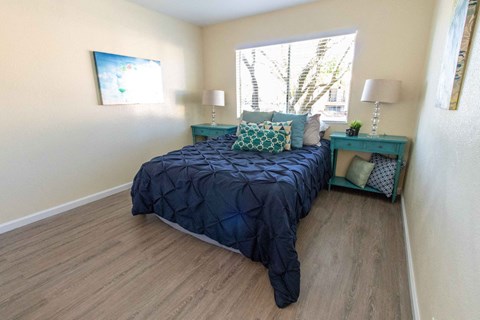 A bedroom with a bed, nightstand, and lamp.