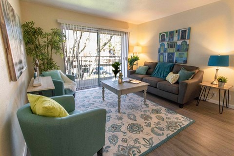 A living room with a green chair and a grey couch.