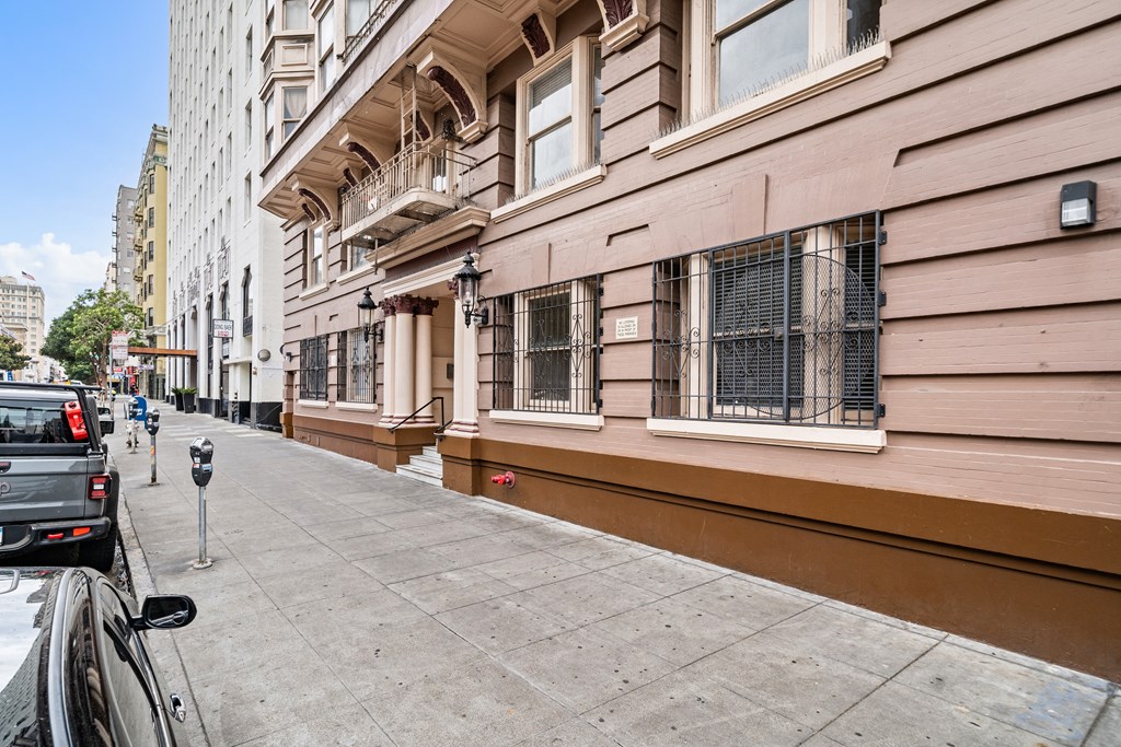 a street view of a building with a sidewalk and a parking meter