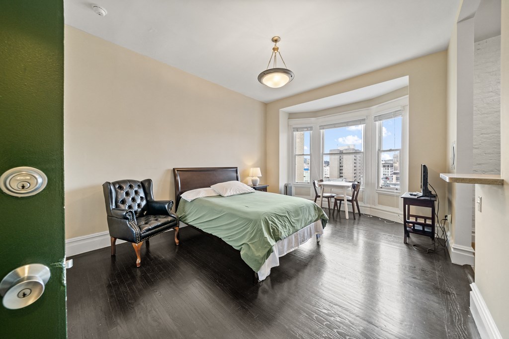 a bedroom with a bed and a chair and a window