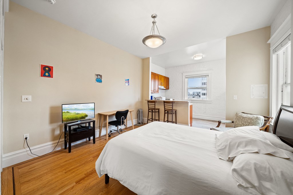 a bedroom with a bed and a desk and a living room