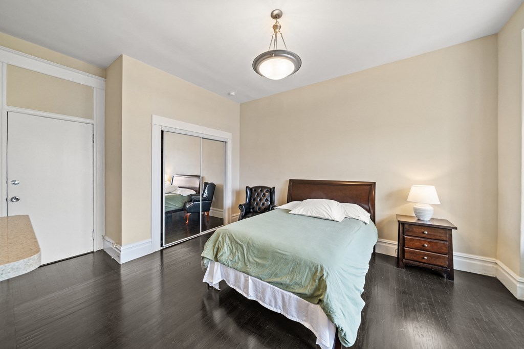 a bedroom with a bed and a closet with a mirror