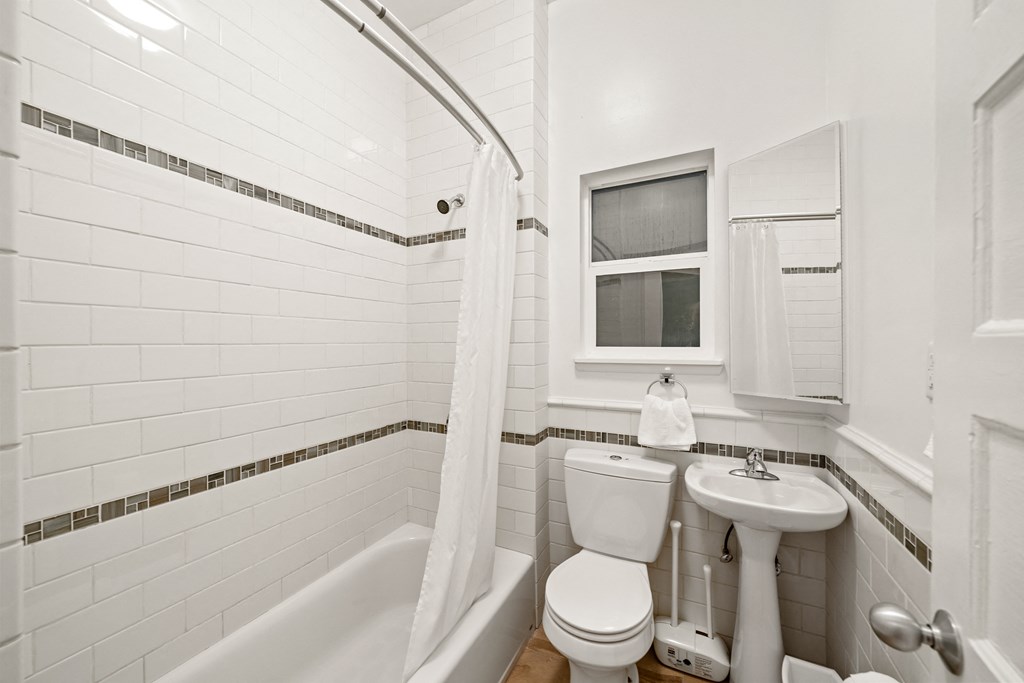 a bathroom with a toilet and a sink and a tub