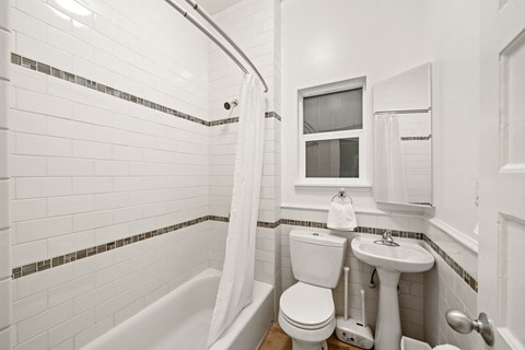 a bathroom with a toilet and a sink and a tub