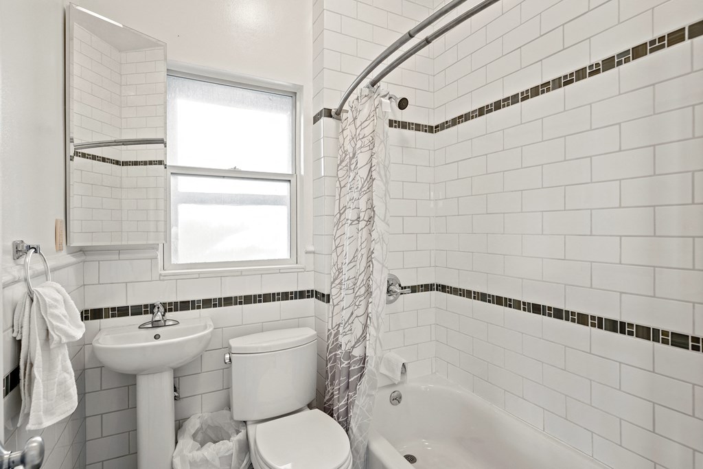 a small white bathroom with a toilet sink and tub