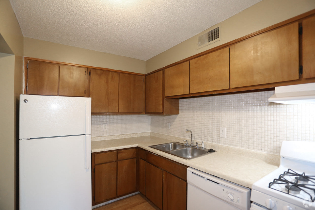 a kitchen with white appliances and wooden cabinets