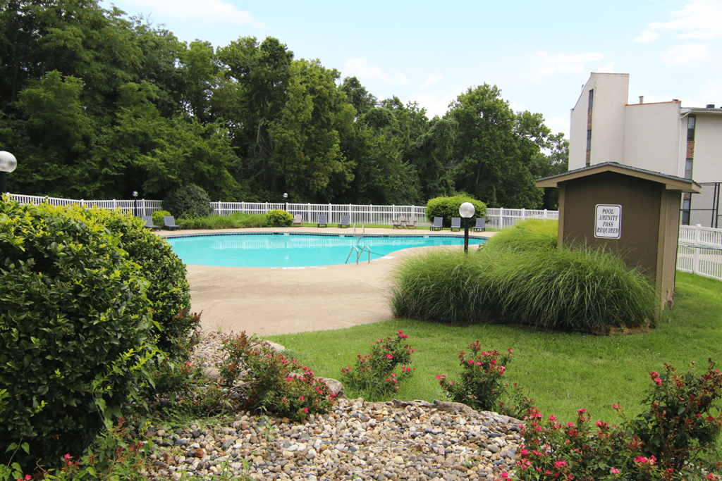 A pool surrounded by a fence and bushes. at Willow Creek, Kansas City, 64114