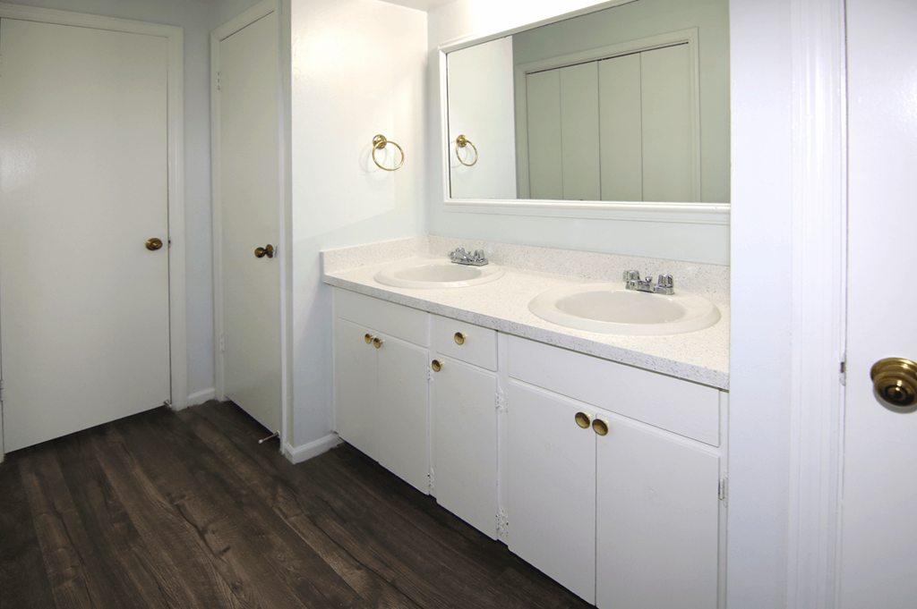 A bathroom with a white vanity and a white door.