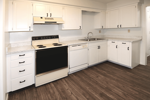 A kitchen with white cabinets and a black stove top.