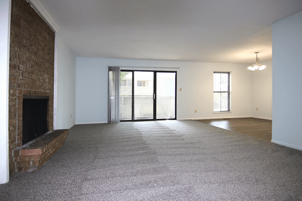 A large, empty room with a fireplace on the left side.