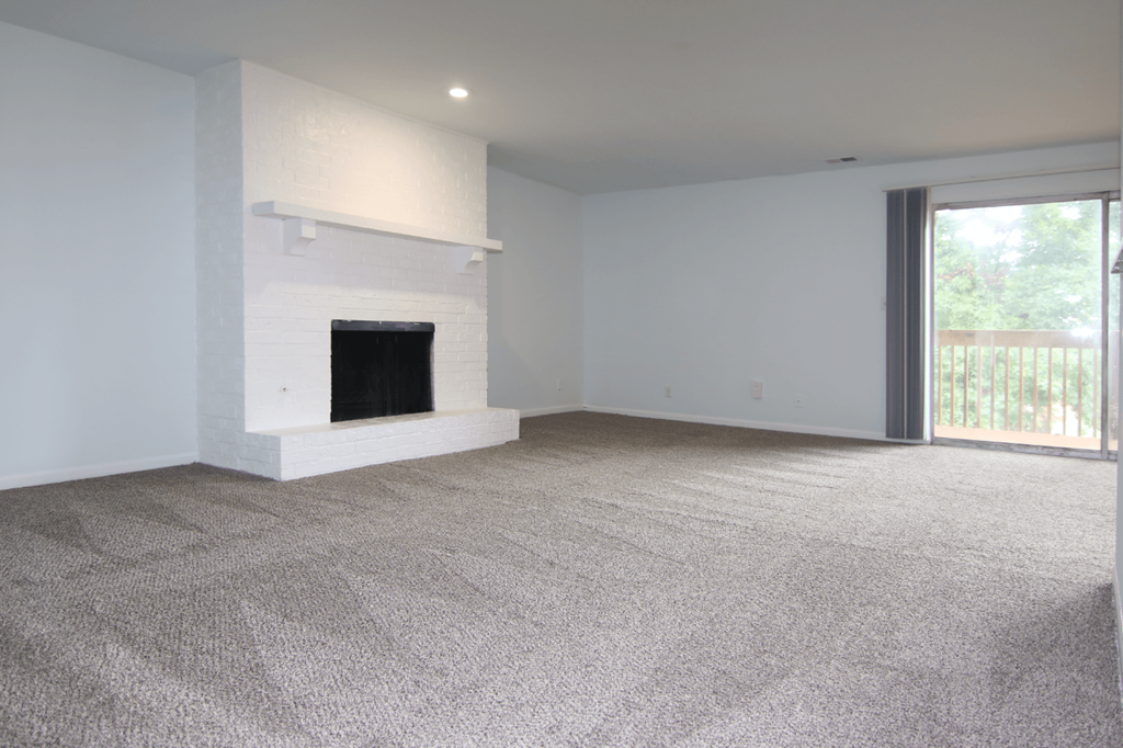 A room with a fireplace and carpeted floor.