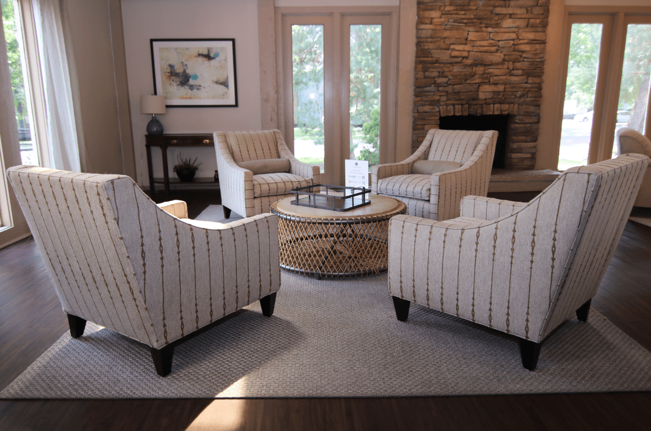 Four striped chairs are arranged around a coffee table in a living room.