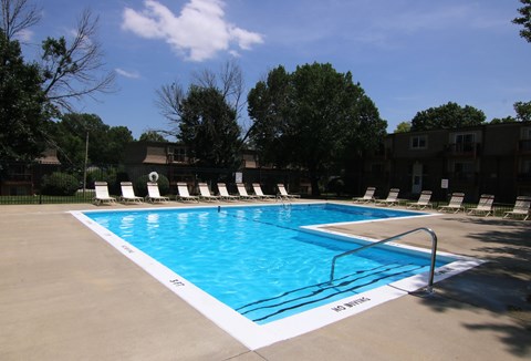 A swimming pool with a white line on the edge and a metal railing.