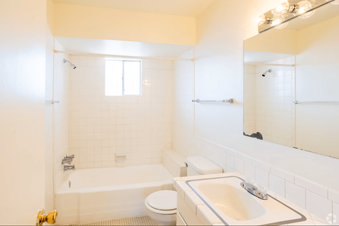 A white bathroom with a tub, toilet, and sink.