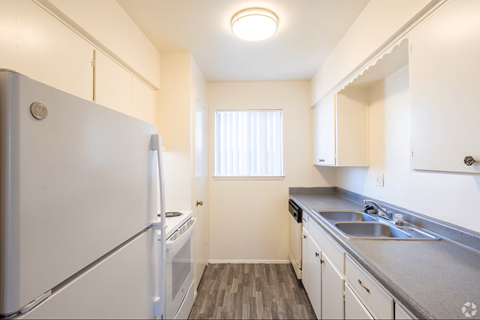 A small kitchen with white appliances and cabinets.