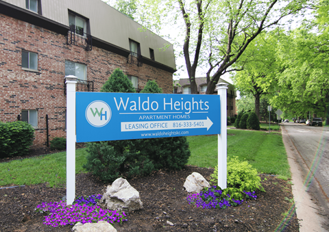 a sign for waldo heights in front of a brick building