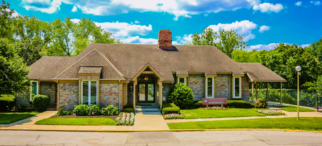 a small brick house with a bench in front of it